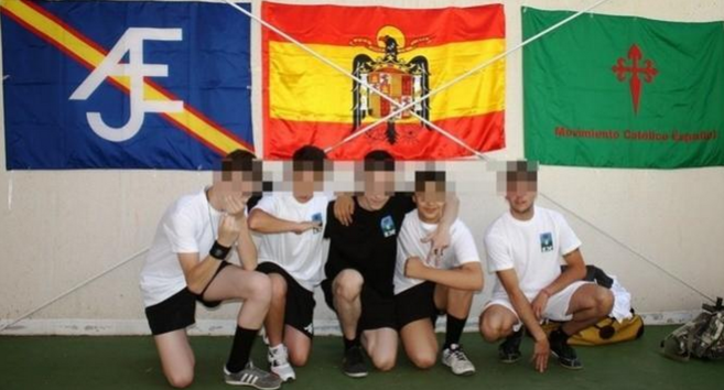 Un grupo de jóvenes posa junto a banderas de grupos de extrema...
