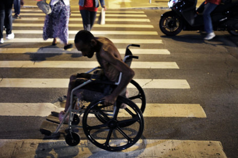 Un hombre con su silla de ruedas en una calle de la ciudad.