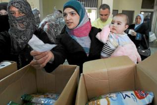 Refugiadas sirias reciben ayuda en Trpoli.