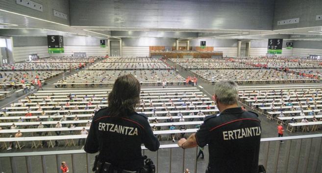 Dos ertzainas observan a los aspirantes a acceder a la Policía vasca.