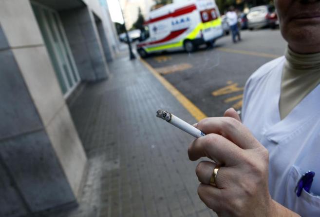 Una sanitaria fumando a la puerta de un hospital.