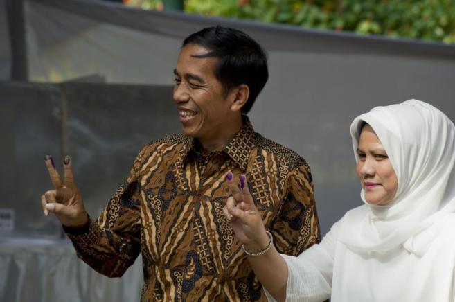 Joko Widodo, junto a su esposa, hace el gesto de la victoria tras...