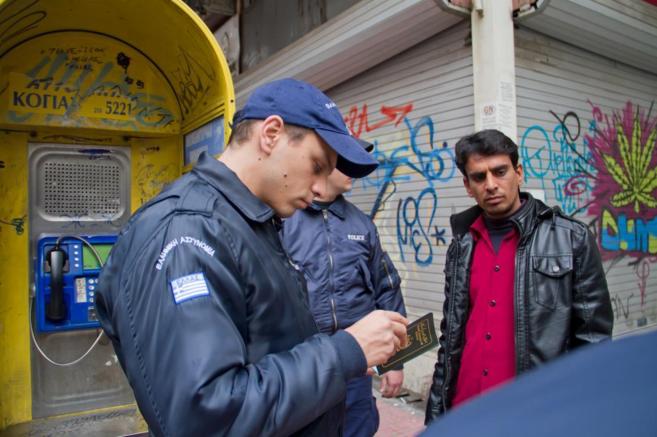 Dos agentes de polica griegos piden la documentacin a un...