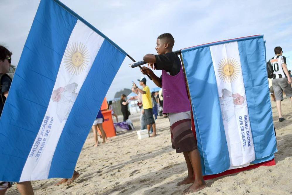 Un hombre vende en la playa banderas de Argentina con la imagen del...