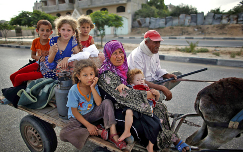 Una familia palestina abandona el norte de Gaza en un carro tirado por...