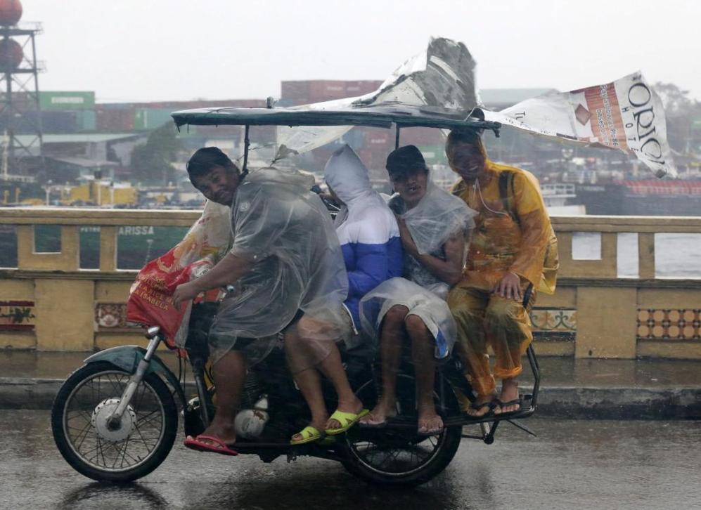 Unos filipinos atraviesan en moto una calle de Manila.