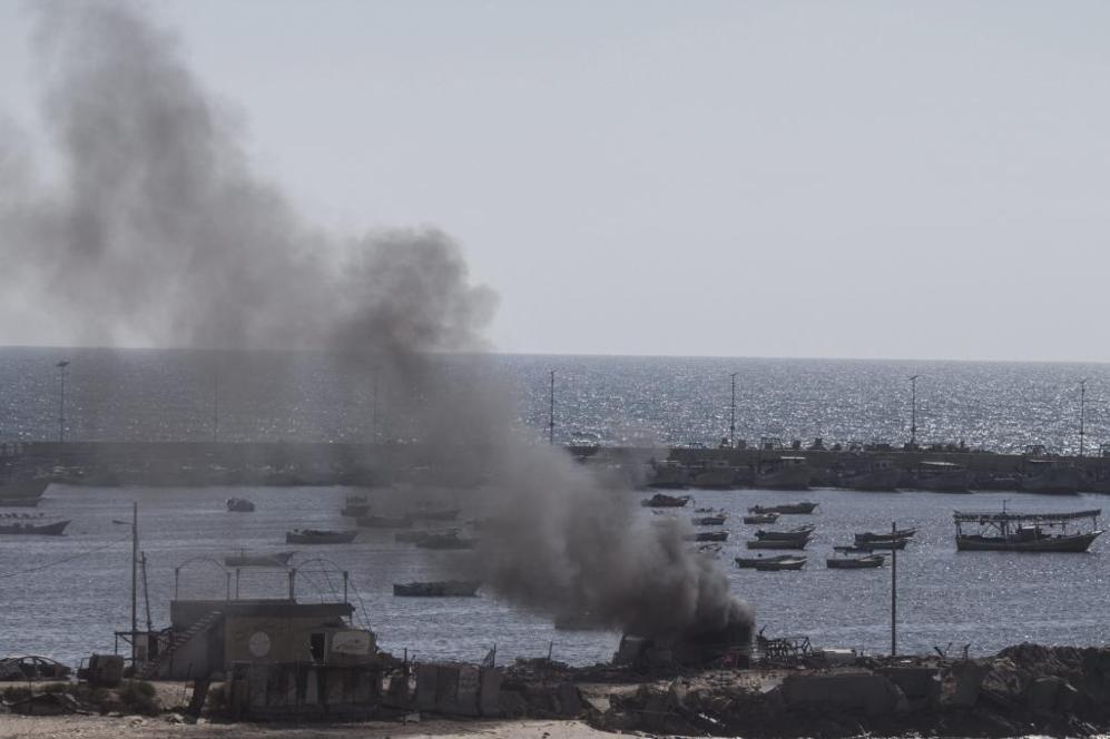 Una columna de humo se eleva desde una estructura del puerto de Gaza...