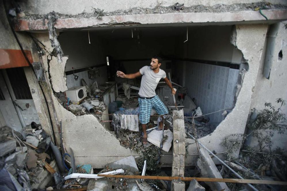 Un palestino inspecciona su casa, destruida por el ataque israelí.