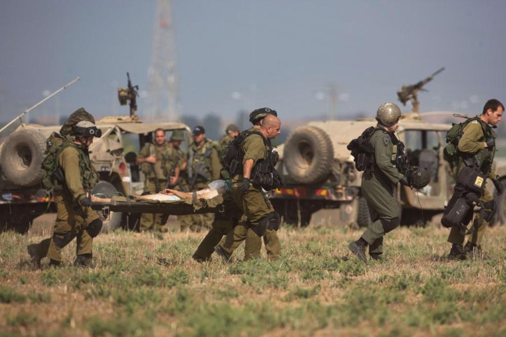 Un soldado israelí herido es trasportado por sus compañeros hasta un...