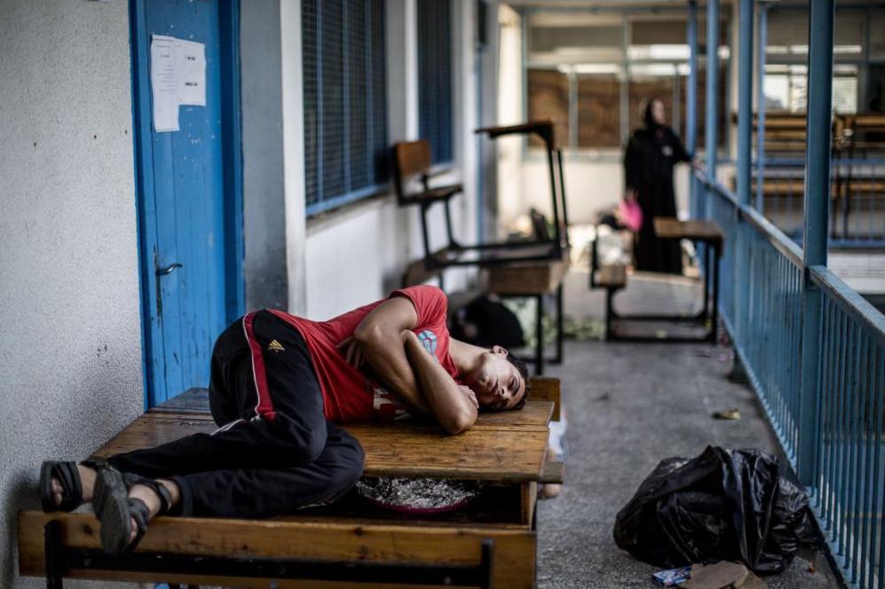 Un palestino desplazado del barrio de Shajaiya, en Gaza, duerme sobre...