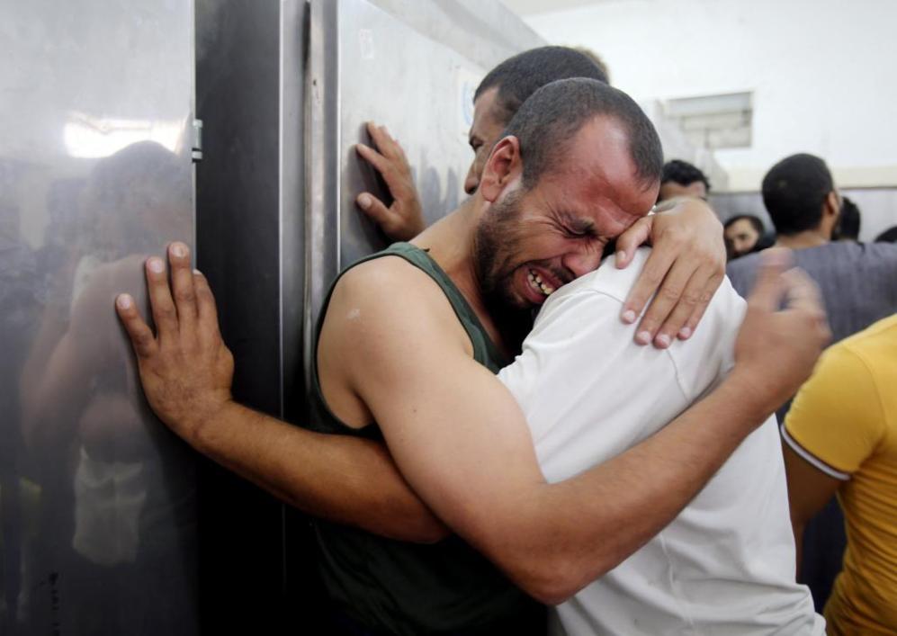 Dos palestinos lloran la muerte de sus allegados por el ataque...