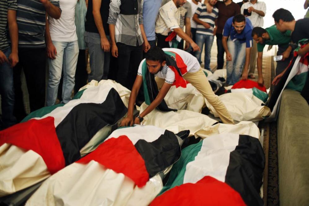 Varios palestinos rodean los cuerpos sin vida de algunos de los...