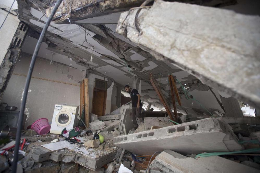 Un palestino camina entre los escombros de un edificio destruido por...