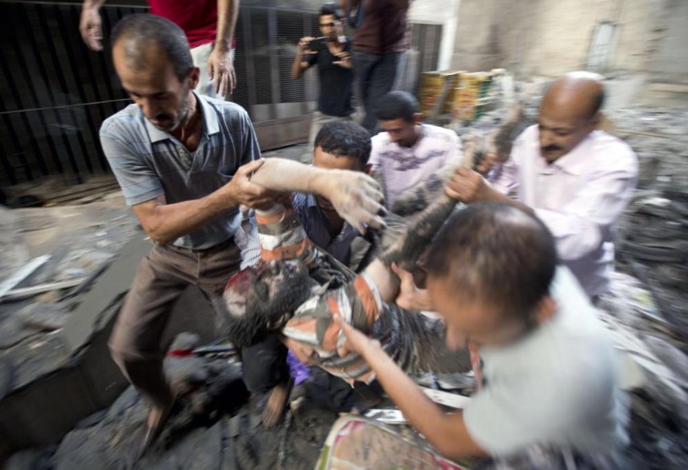 Varios palestinos evacuan a un hombre de entre los escombros...