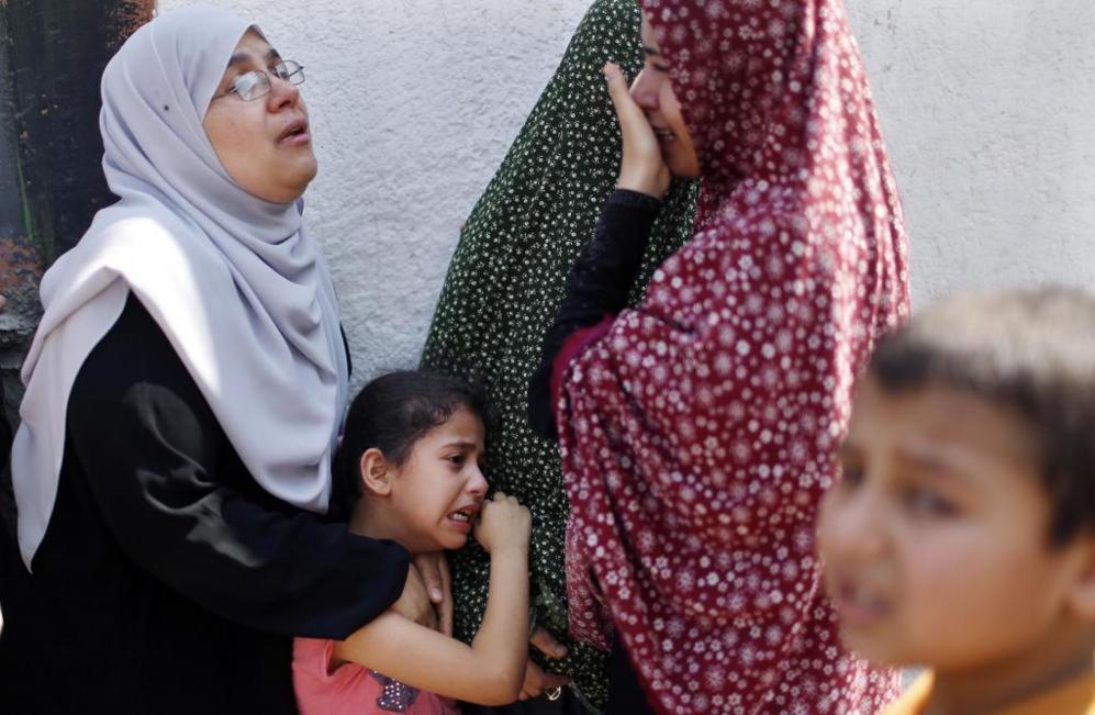Varias mujeres palestinas lloran a las afueras de un hospital tras...