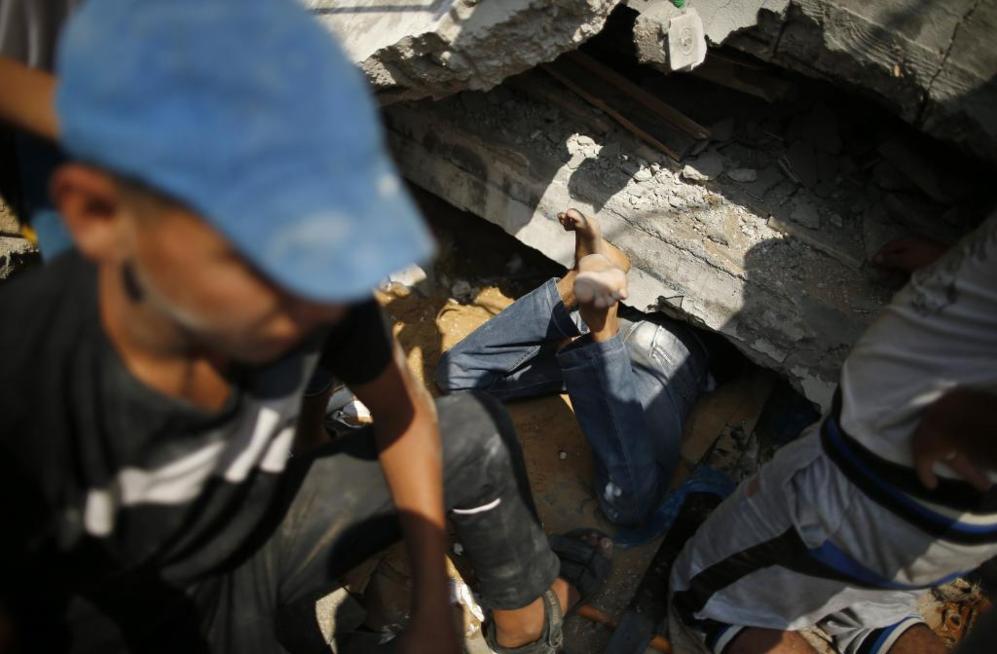 Los palestinos buscan supervivientes entre los restos de un edificio...