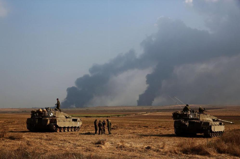 Los soldados israels observan las nubes de humo del enclave...