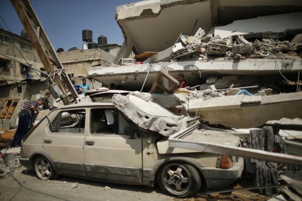 Varios palestinos inspeccionan las ruinas de un edificio