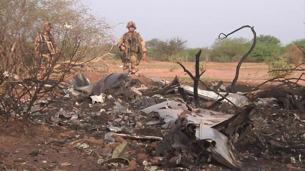 Dos militares inspeccionan los restos calcinados del vuelo AH5017,...