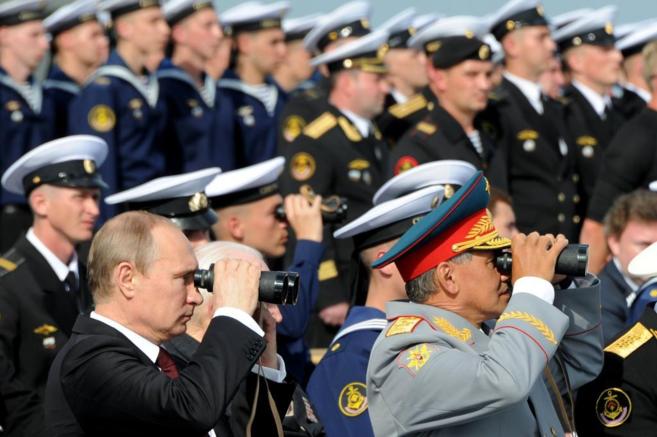 Vladmir Putin, detrs del ministro ruso de Defensa, Sergei Shoigu, en...