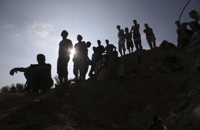Palestinos miran a los equipos de rescate en busca de vctimas bajo...