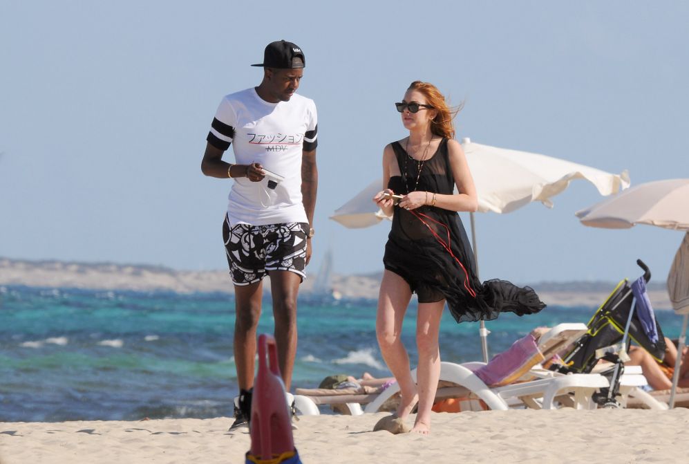 Lindsay Lohan pasea por la playa de Ibiza con un amigo.