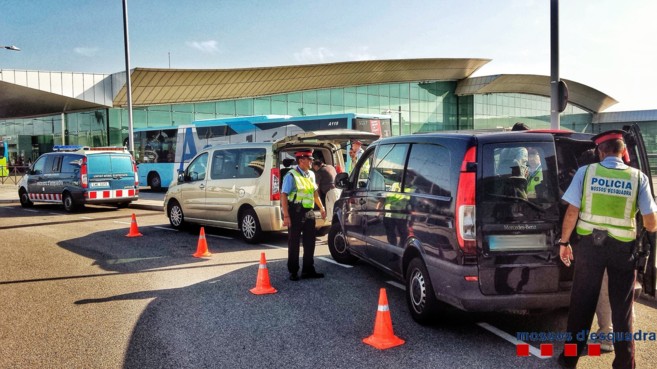 Efectivos policiales registrando varios vehculos en el aeropuerto...