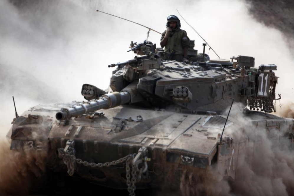 Un tanque del ejrcito israel avanza junto a la frontera entre...