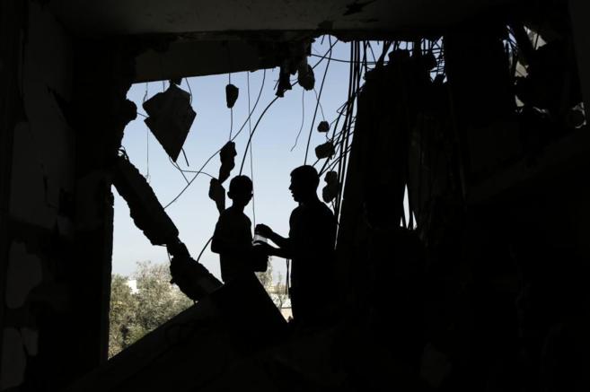 Palestinos desplazados revisan los daos en sus casas durante la...