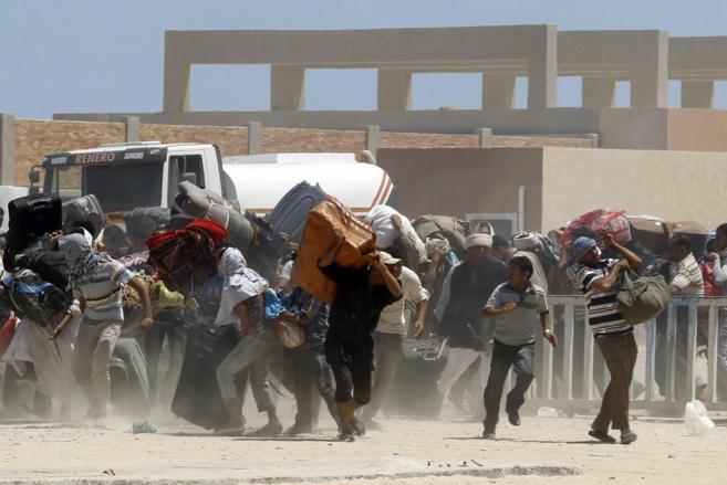 Decenas de egipcios abandonan Libia, a travs del paso Ras Jedir,...