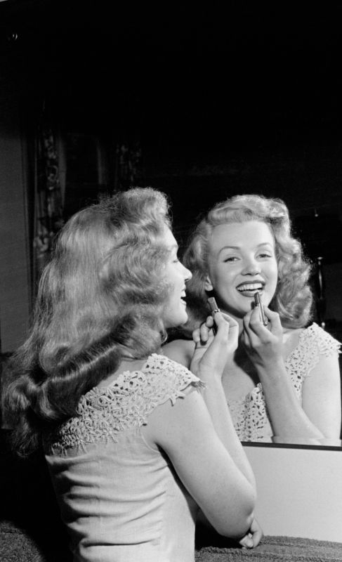 Marylin se maquilla frente al espejo en 1949.