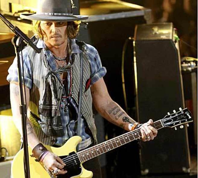 El actor Johnny Depp empuando su guitarra elctrica durante la...