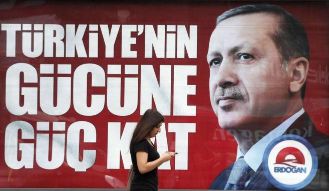 Una mujer pasa por delante de un cartel electoral de Erdogan.