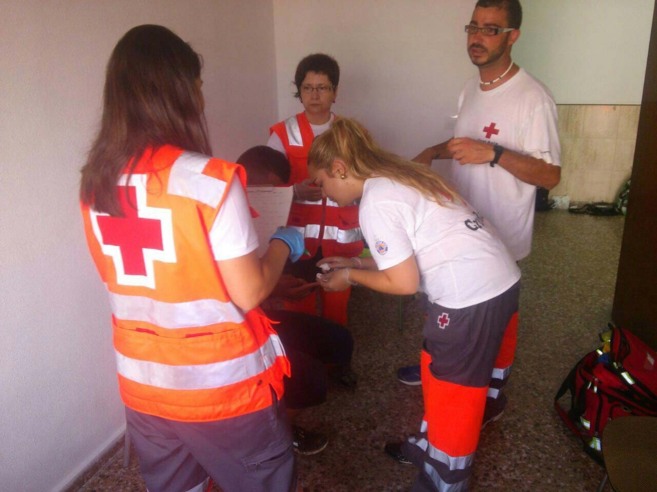Personal de Cruz Roja atendiendo a uno de los tripulantes de la...