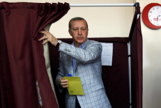 Recep Tayyip Erdogan prepara su voto en un colegio electoral de...