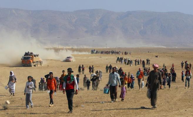 Miembros de la minoría yazidí evacuando el Monte Sinyar ante los...