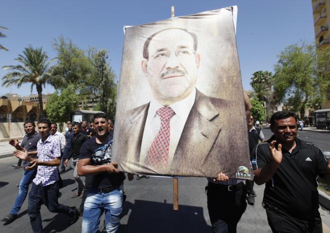 Partidarios de Nuri al Maliki portan un pster del primer ministro...