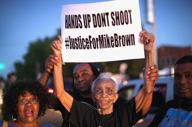 Una vecina de Ferguson sostiene un cartel que dice: "No disparen,...