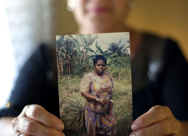 Una mujer muestra una fotografia de la misionera repatriada a Espaa...