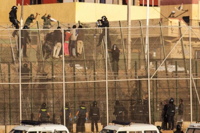 La polica marroqu hostiga a los inmigrantes que encaramados a la...