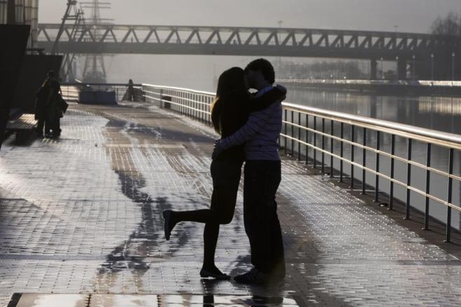 Una pareja se besa en el puente de Abandoibarra, en Bilbao.