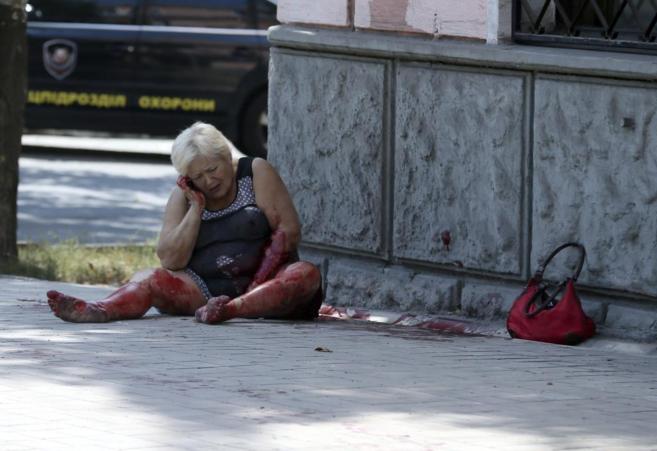 Una mujer permanece herida en el suelo tras un ataque del ejrcito...