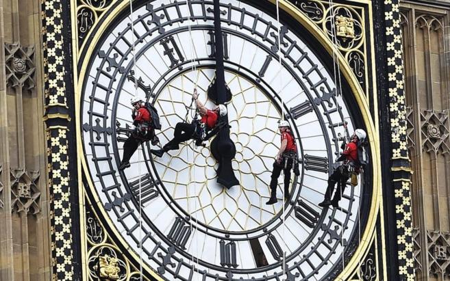 Varios hombres limpian el Big Ben en Londres, Reino Unido,