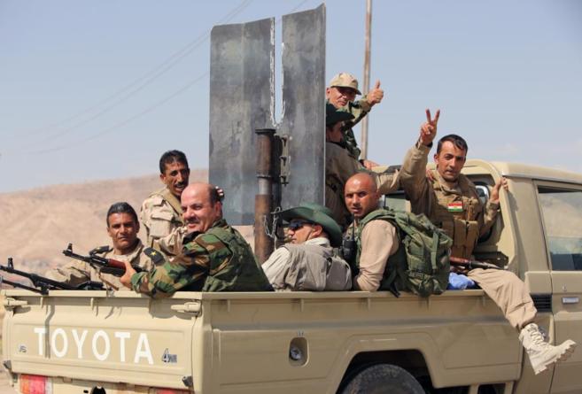 Varios combatientes kurdos celebran que han recuperado la presa de...