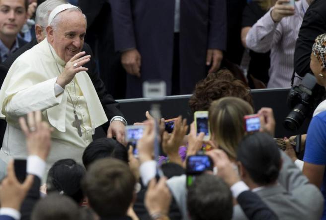 El Papa saluda a los fieles que le fotografan antes de comenzar la...