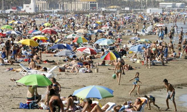 Imagen de a valenciana playa de la Malvarrosa llena de turistas.