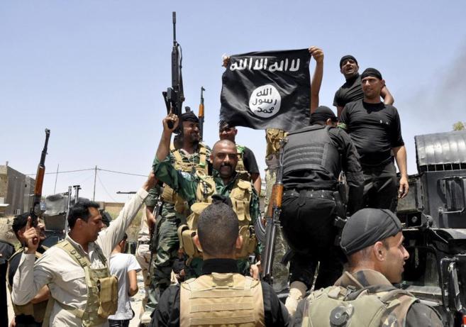 Soldados chiíes retiran una bandera del IS en Diyala.