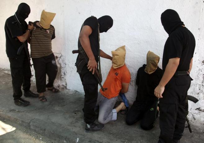 Miembros de Hamas preparan a los supuestos colaboracionistas para su...