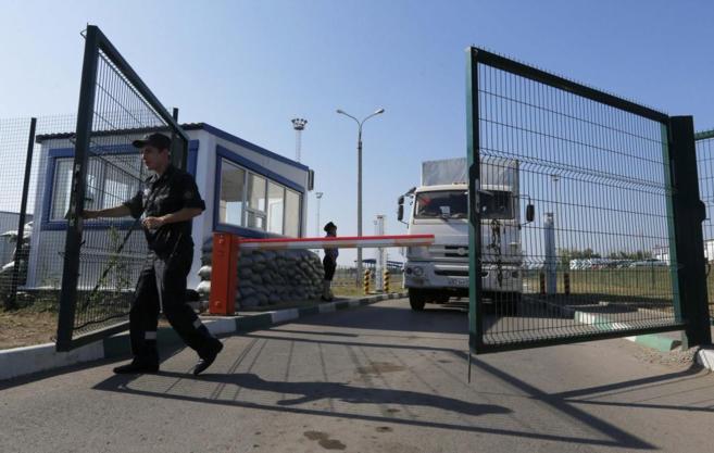 Un guardia de frontera abre la puerta al convoy ruso tras abandonar...