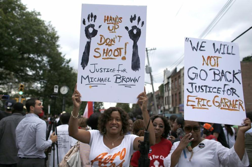 Mujeres sostienen carteles durante la marcha. El de la izquierda dice:...